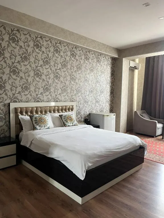 Guest room with patterned wallpaper and a double bed